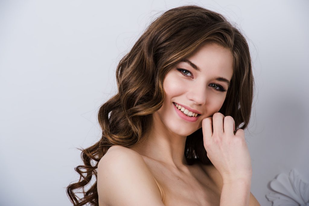 Portret de aproape al unei mirese zâmbitoare cu un coc elegant și rafinat.