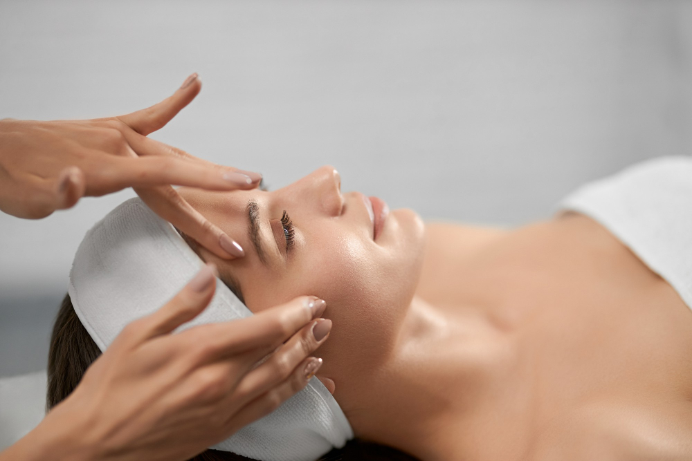 Prim plan al unei femei caruia i se aplica masaj facial pentru relaxare