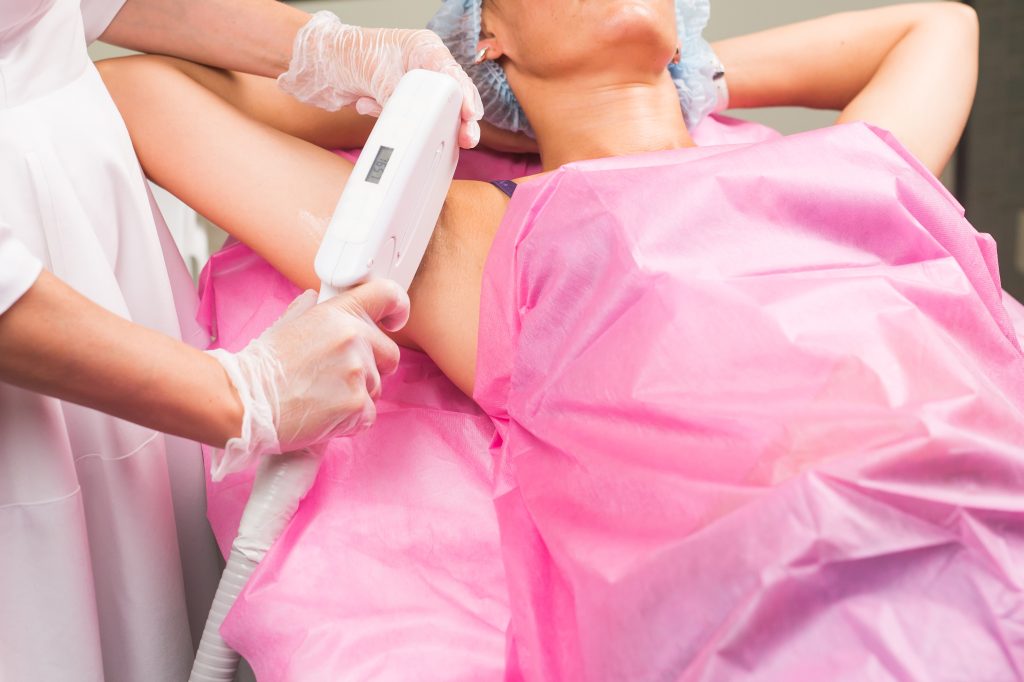 Cosmetician profesional ce aplica un tratament de epilare definitiva